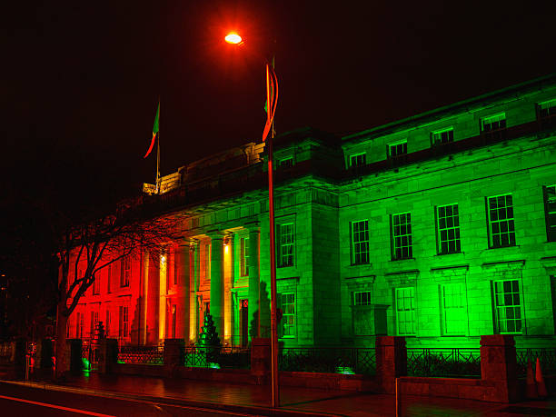 Cork City Hall illuminated in green and red at night, designed on classic lines to harmonise with 18th-19th century Georgian architecture, a civic landmark of heritage and urban identity.