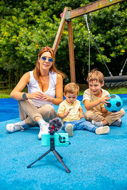 Content creator recording a video with her sons at the playground