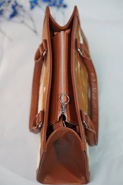 istock Top-down view of a tan and white cowhide handbag, showcasing its secure zip closure and spacious interior. 2245798708