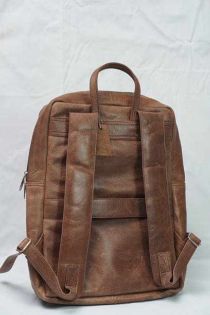Back view of a versatile brown leather backpack, showcasing its adjustable straps and durable design.