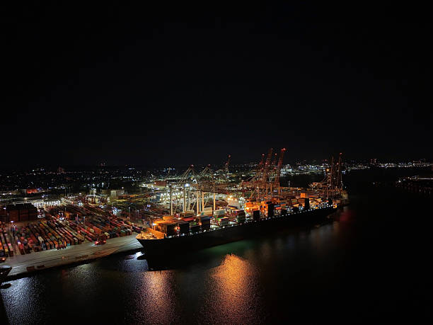 istock Aerial top view container ship full of containers for a logistics import, export, shipping or transportation concept background. Night shooting. 2245800169