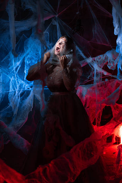istock Scared woman trapped in spider web on blue red background. 2245801347
