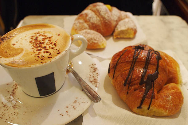 Cappuccino and cornetto brioche croissant at the cafe in Italy