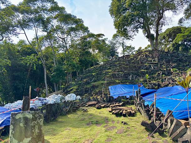 istock Archaeological site (Gunung Padang or similar megalithic structure) showing massive stacked stones, covered with tarps during restoration/preservation. 2245804489