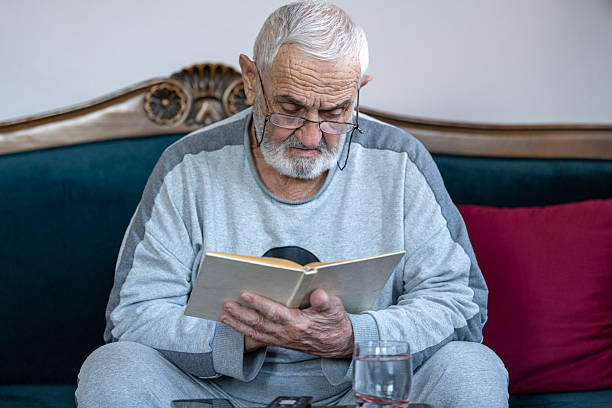 istock Senior man enjoying time at home by reading his favorite book 2245806061