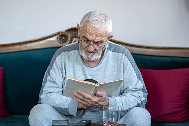 istock Senior man enjoying time at home by reading his favorite book 2245806128