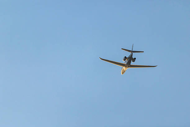 istock Private jet flying high in clear blue sky 2245807728