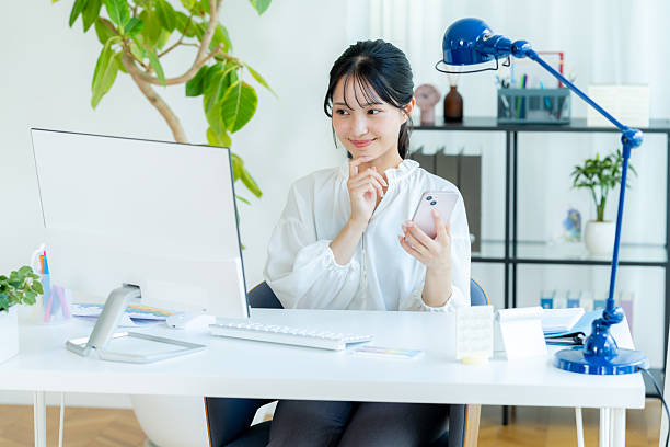 istock Business woman with smartphone in office 2245808052