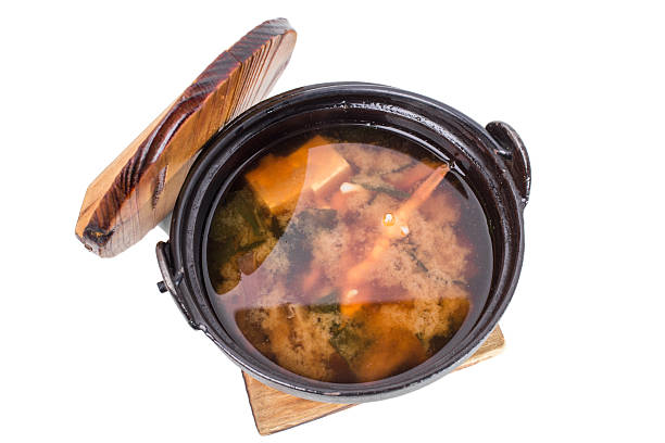 Delicious vegetable soup with tofu on old metal pot. Isolated on a white background.