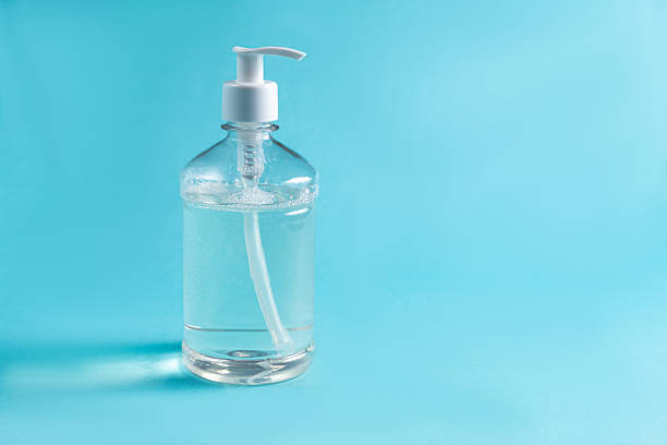 istock Container with alcohol gel on the light blue background 2245810717