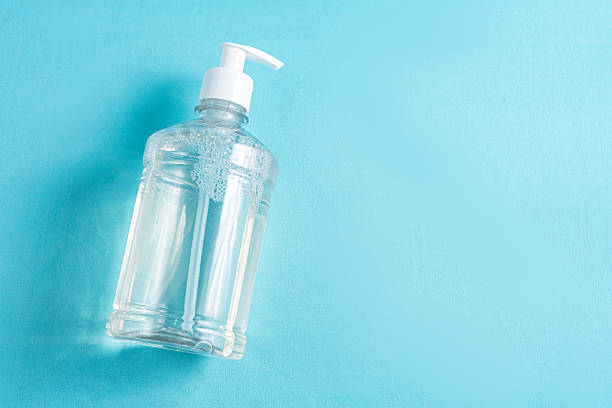 istock Container with alcohol gel on the light blue background 2245810740