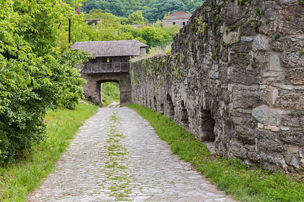 Medieval stone city defensive wall and Upper gate in it in the southwestern part of the Old town in Kamianets-Podilskyi in overcast day, Ukraine