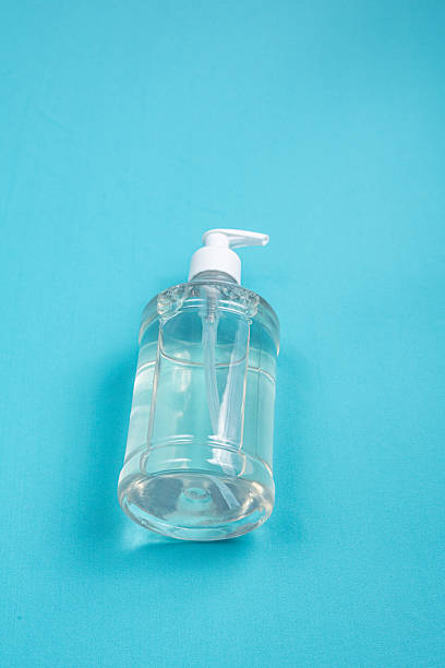istock Container with alcohol gel on the light blue background 2245811460