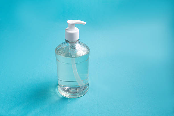 istock Container with alcohol gel on the light blue background 2245812088