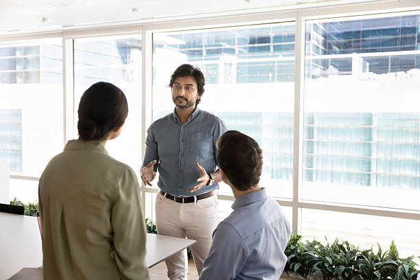 istock Experienced mature businessman engage young multiethnic colleagues in thoughtful discussion 2245812879