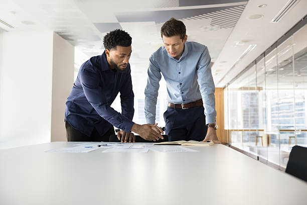 istock Two gen z workmates of diverse ethnicity collaborating at workplace 2245812988