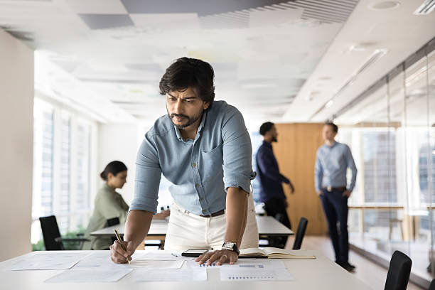istock Concentrated male project manager work with statistics in paper documents 2245814778