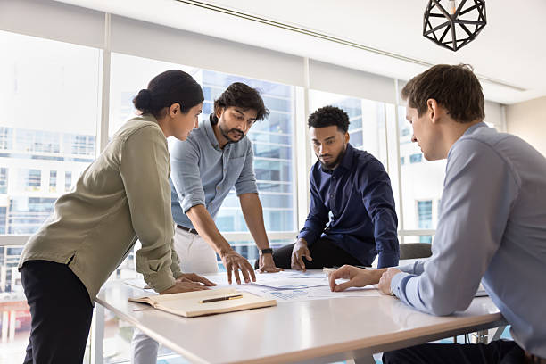 istock Creative young multiethnic business team engaged in paperwork at workplace 2245815194