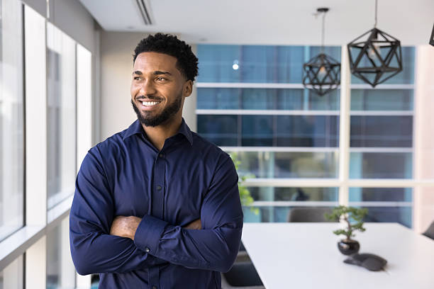 istock Smiling Black man entrepreneur look at window in office boardroom 2245815822