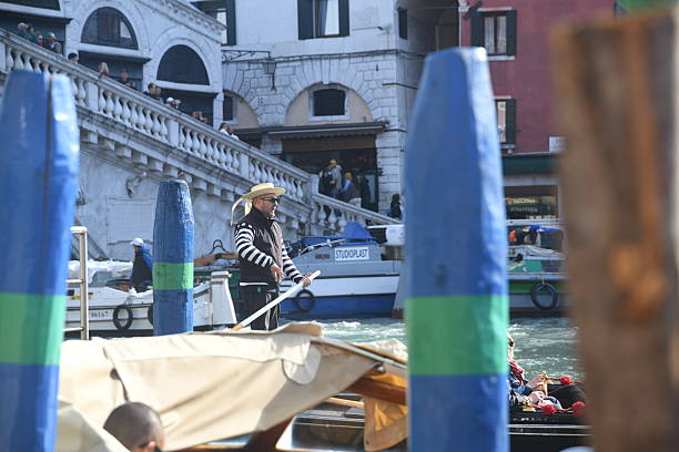 Venice, Italy -  October 24, 2025 - A gondolier transporting tourists on a gondola, the typical venetian boat