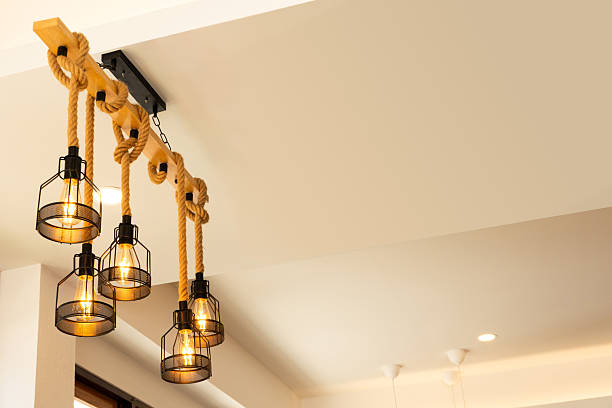 istock lights with vintage Edison bulbs hanging from rope on ceiling, creating warm ambient lighting for modern loft, cafe, or interior design decoration. 2245817593