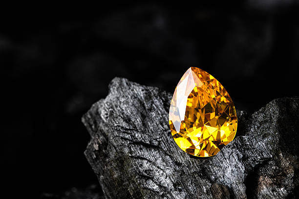 istock Yellow sapphire gemstone on black coal background 2245817675