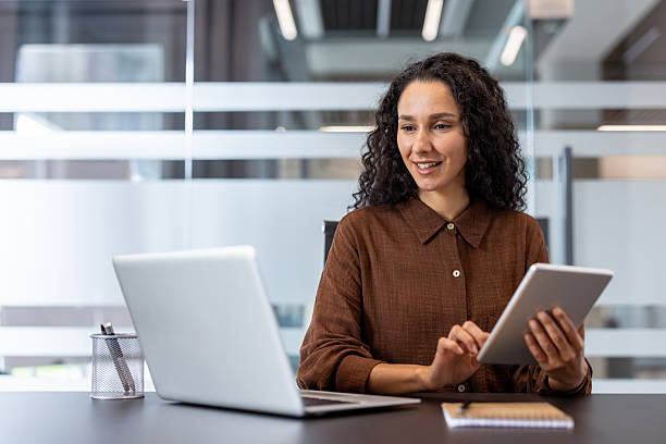 istock Professional individual using a laptop and tablet in a modern office 2245818064