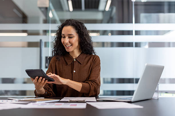 istock Businesswoman using calculator at a desk in a modern office setting 2245818087