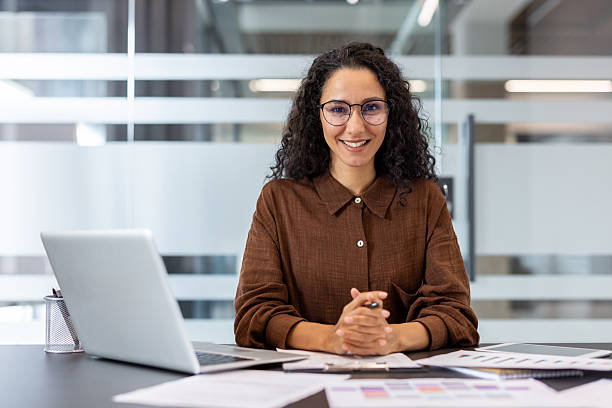 istock Professional woman in office setting working and smiling at a desk 2245818125