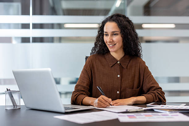 istock Confident professional woman working at her desk in a modern office environment 2245818127