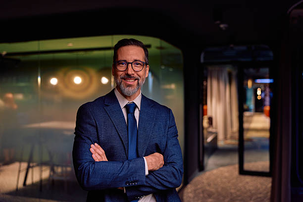 istock Confident businessman standing with crossed arms in office 2245818538