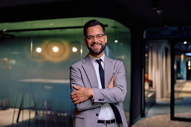istock Confident businessman standing in modern office smiling 2245818564
