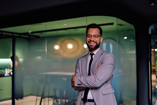 Confident businessman standing in modern corporate office