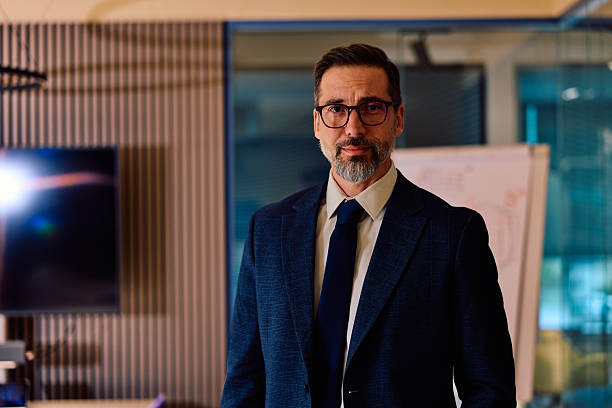 istock Mature businessman with glasses looking at camera in office 2245818642