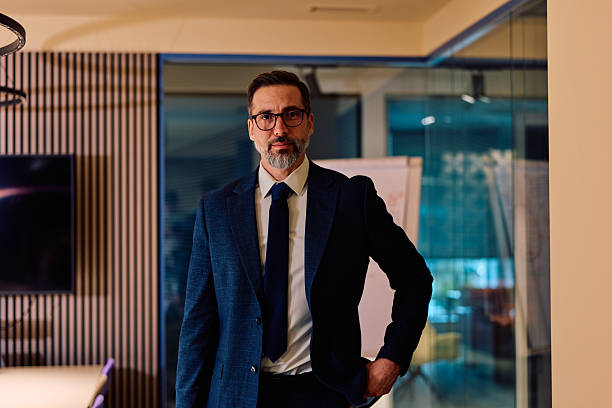 Serious businessman standing in modern office with confident pose
