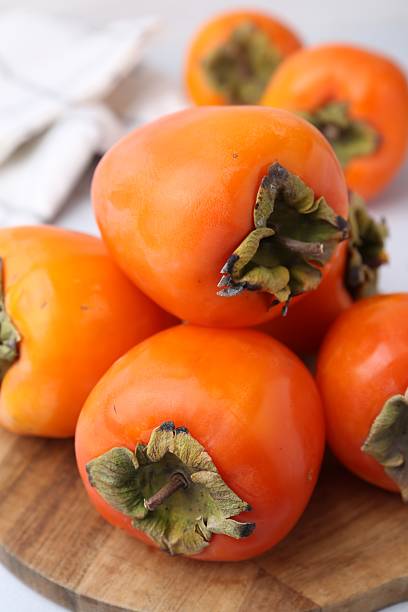 istock Delicious fresh juicy persimmons on table, closeup 2245818934