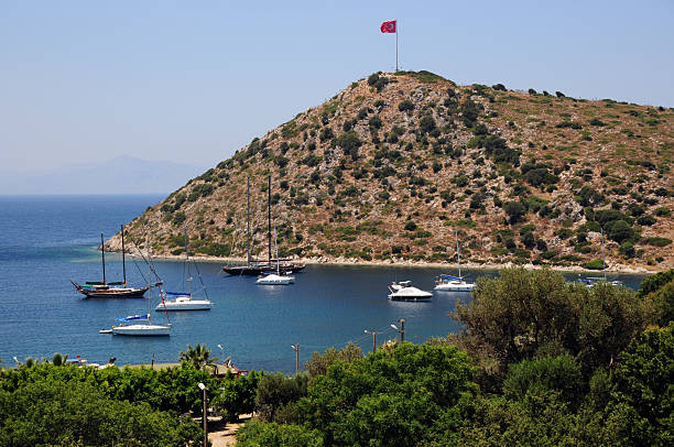 View of the Bodrum inscription in large letters on the mountainside with houses at sunset. Bodrum welcome sign at the entrance to the city, Turkey.