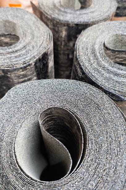 istock Rolls of black felt lining stacked at a construction site ready for installation in a roofing project during daytime 2245819852