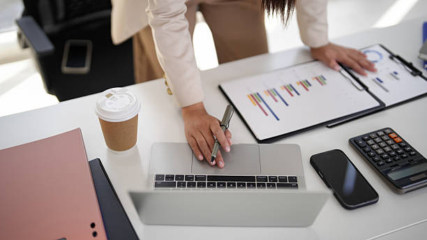 istock Business professional hand analysis financial data laptop computer pen review reports plan strategy modern office desk 2245825089