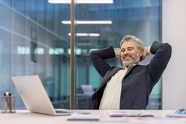 istock Mature businessman relaxing after successful workday in office 2245825416