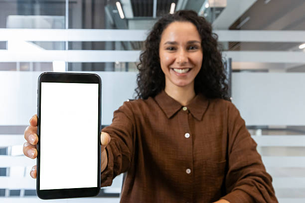 istock Professional woman showcasing smartphone in modern office environment 2245826989