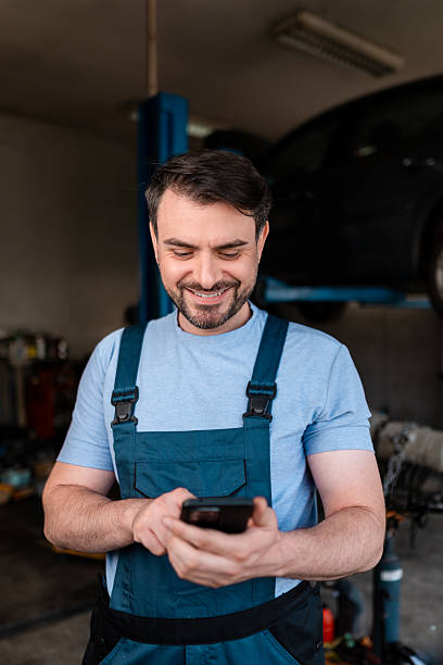 istock Mechanic checking his phone while working in an auto repair shop 2245830486