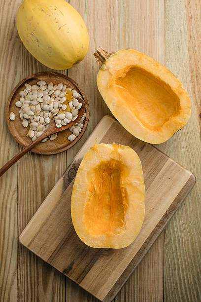 istock Overhead view of Spaghetti squash on a wooden background with squash seeds 2245831363