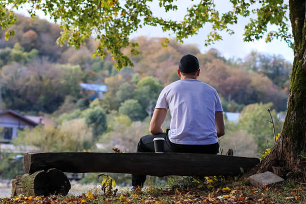istock Man holding coffee cup while contemplating autumn scenery from rear 2245833711