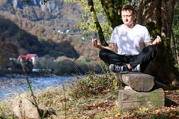 istock Man in meditation pose with thumb-index circles outdoors 2245833846