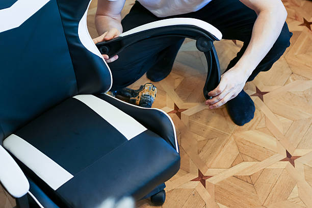 Person finalizing gaming chair arm assembly on floor