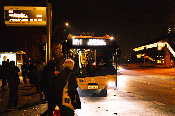 Berlin, Germany – November 7, 2025: BVG night bus line M41 to Sonnenallee stops at a bus station at night with passengers boarding. Streetlights illuminate the scene in the Kreuzberg area.