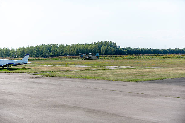 istock Airplanes on a sunlit grass runway, calm readiness before jump in open sky 2245838473