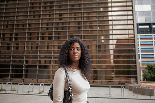Confident young woman walking down an urban street.