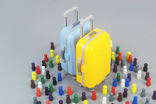 Two travel suitcases and many people figures on grey background.